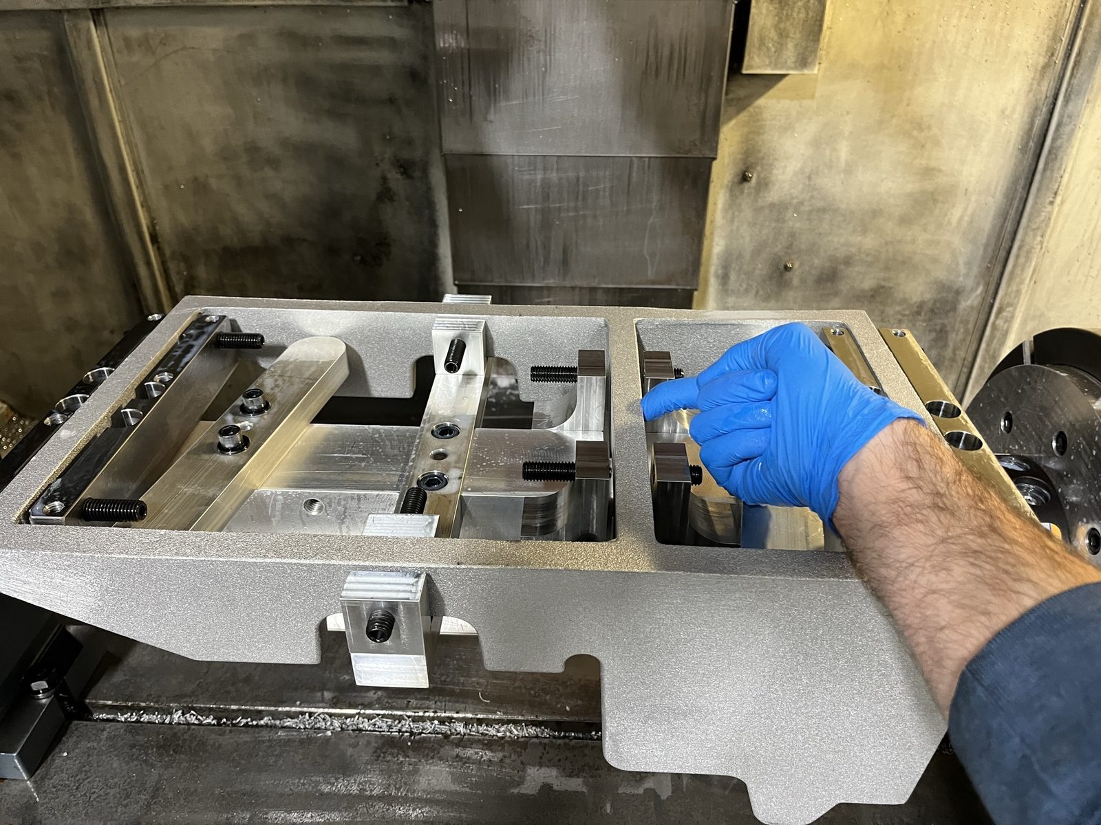 Aluminum machining fixture with clamps set up inside a machine