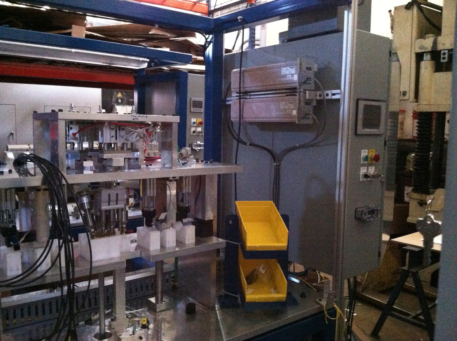 Special machine with a blue frame, control cabinet and yellow parts bins